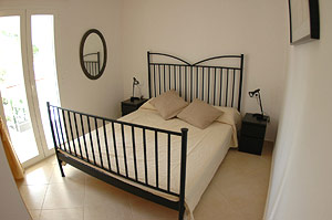 The bedroom with access to the front terrace (identical in both apartments).